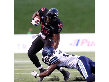 Marcus Henry of the Ottawa Redblacks is tackled by Jalil Carter of the Toronto Argonauts at TD Place in Ottawa during the franchise home opener of the Redblacks on Friday, July 18, 2014.
