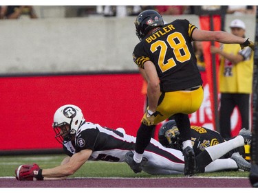 Ottawa Redblacks slot back Matt Carter stretches for a touchdown past Hamilton Tiger-Cats defensive back Craig Butler in CFL action in Hamilton, Ont., Saturday, July 26, 2014.