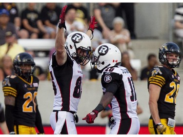 Ottawa Redblacks slot back Matt Carter celebrates his touchdown with teammate Kierrie Johnson, right.