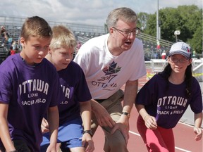 Mayor Jim Watson gets into the spirit of track and field Thursday while announcing the city will host the Athletics Canada Junior/Senior games in 2017 and 2018.