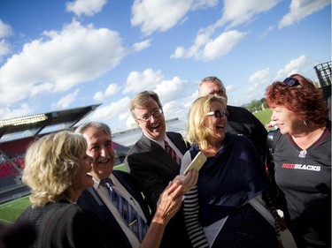 Mayor Jim Watson laughs after taking a selfie with Ottawa city councillors at the official opening of TD Place at Lansdowne Wednesday July 9. 2014.