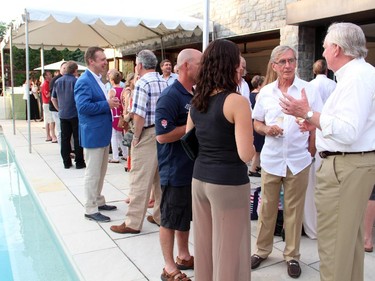 Michael Potter, founder of Vintage Wings Canada and honorary colonel of the Canadian Forces Snowbirds, is seen in a poolside conversation with lawyer Greg Kane and other guests of the Hadfield Youth Summit Soirée he hosted Monday, June 30, 2014, at his home.