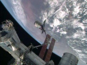 NASA photo showing the Canadarm2 reaching out to grab an unmanned cargo ship that was guided through its approach with sensors from an Ottawa company, Neptec Design Group.