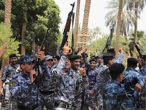 Newly recruited policemen celebrate their recruitment at a police recruiting office in Baghdad, Iraq, Saturday, July 5, 2014. Iraq's Prime Minister Nouri al-Maliki removed the chief of the army's ground forces and the head of the federal police from their posts Saturday as part of his promised shakeup in the security forces following their near collapse in the face of a militant blitz last month, an official said.