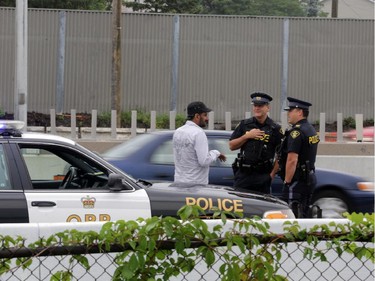 OPP officers near scene as traffic on the eastbound Queensway / 417 moves slowly through the downtown core after a tractor trailer jack-knifed just east of Nicholas St. in Ottawa, Thursday, July 31, 2014.