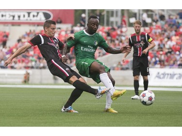 Ottawa Fury FC defenceman Carl Haworth (left) fights for the ball with New York Cosmos midfielderJemal Johnson (right) during their NASL soccer match-up at TD Place in Ottawa, July 20, 2014.