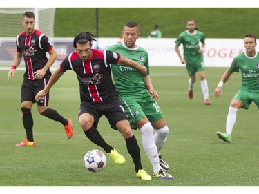 Ottawa Fury FC midfielder Tony Donatelli  (left) fights for the ball with New York Cosmos midfielder Danny Szetela (right) during their NASL soccer match-up at TD Place in Ottawa, July 20, 2014.
