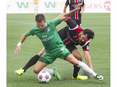 Ottawa Fury FC midfielder Tony Donatelli  (right) fights for the ball with New York Cosmos defenceman Ayoze(left) during their NASL soccer match-up at TD Place in Ottawa, July 20, 2014.