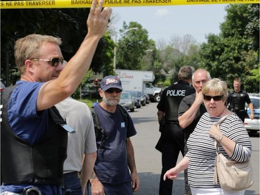 Ottawa police escort evacuated residents back to their homes after a tactical squad executed a search warrant at a home located at 19 Topley Crescent in the Hunt Club area on Friday, July 18, 2014.
