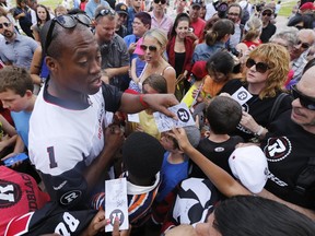 Ottawa RedBlacks QB Henry Burris signs autographs during a pep rally at city hall Thursday, July 17, 2014.