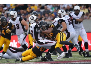 Marcus Henry #16 of the Ottawa Redblacks is hit during CFL game action by Marcellus Bowman #38 of the Hamilton Tiger-Cats on July 26, 2014 at Ron Joyce Stadium in Hamilton, Ontario, Canada.