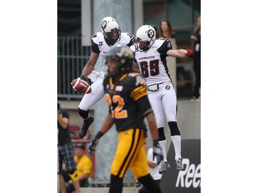 Marcus Henry #16 of the Ottawa Redblacks celebrates his touchdown with Matt Carter #85 during CFL game action against the Hamilton Tiger-Cats on July 26, 2014 at Ron Joyce Stadium in Hamilton, Ontario, Canada.
