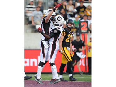 Matt Carter #85 of the Ottawa Redblacks celebrates his touchdown with Kierre Johnson #10 during CFL game action against the Hamilton Tiger-Cats on July 26, 2014 at Ron Joyce Stadium in Hamilton, Ontario, Canada.