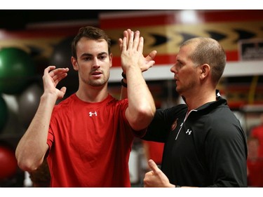 Ottawa Senators' NHL prospect Ben Harpur (L) gets some help from Chris Schwarz (R), Conditioning Coach, during their annual development camp at Canadian Tire Centre in Ottawa on July 03, 2014.