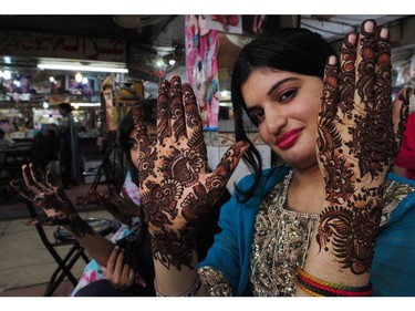 A Pakistani woman displays her hands decorated with traditional henna design at a mall ahead of the Muslim festivities of Eid al-Fitr, in Karachi on July 26, 2014. Muslims around the world are preparing to celebrate the Eid al-Fitr holiday, which marks the end of the fasting month of Ramadan.