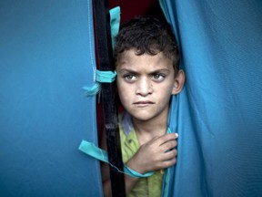 A displaced Palestinian boy looks out from a makeshift tent at the al-Shifa hospital in Gaza City where many Palestinians have have taken refuge after fleeing attacks in the Shejaiya neighbourhood of the city, on July 31, 2014. With more than 220,000 Palestinians already sheltering in UN facilities -- four times the number from the last Gaza conflict in 2008-2009 -- the top UN refugee official Philippe Krahenbuhl said he had reached breaking point.