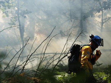 Parks Canada workers set fire to a portion of Camelot Island in the Thousands Islands in Mallorytown, ON, Tuesday July 22, 2014. The fire is intended to protect the pitch pine, a rare, fire-dependant tree species unique to the area.