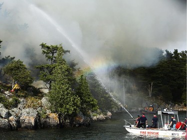 Parks Canada workers set fire to a portion of Camelot Island in the Thousands Islands in Mallorytown, ON, Tuesday July 22, 2014. The fire is intended to protect the pitch pine, a rare, fire-dependant tree species unique to the area.