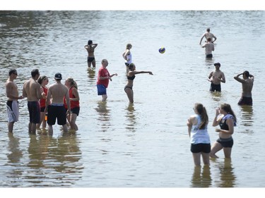People cool off in the water between matches at the HOPE Volleyball Summerfest at Mooney's Bay Beach in Ottawa on Saturday, July 12, 2014.
