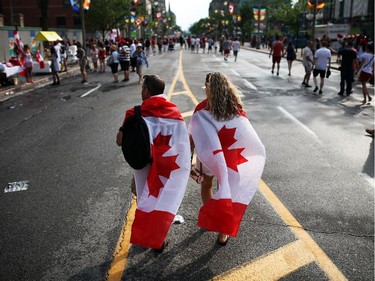 People enjoy pockets of sunshine between rain showers in downtown Ottawa during Canada Day festivities on July 1, 2014.