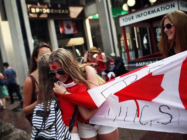 People enjoy pockets of sunshine between rain showers in downtown Ottawa during Canada Day festivities on July 1, 2014.