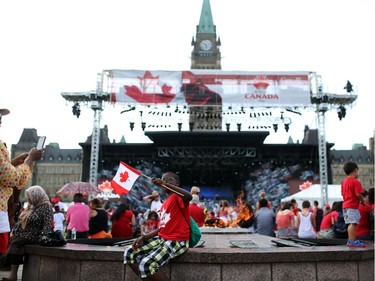 People enjoy pockets of sunshine between rain showers in downtown Ottawa during Canada Day festivities on July 1, 2014.