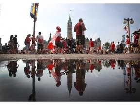 People enjoy pockets of sunshine between rain showers in downtown Ottawa during Canada Day festivities on July 1, 2014.