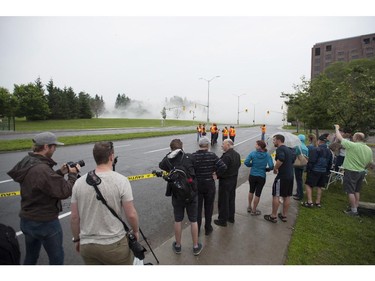 People look on at Carling Avenue after the demolition of the Sir John Carling building in Ottawa on Sunday, July 13, 2014. The former headquarters of Agriculture and Agri-Food Canada at 930 Carling, completed in 1967, is being demolished at a cost of $4.8 million.