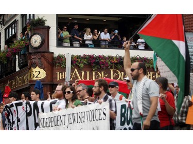 People march with the Palestinian Flag on Saturday, July 26, 2014 as they call for an end to the war in Gaza.