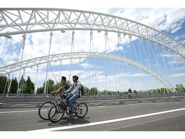 People ride bikes at the opening of the Strandherd-Armstrong Bridge in Ottawa on Saturday, July 12, 2014. The bridge connects the communities of Barrhaven and Riverside South over the Rideau River.