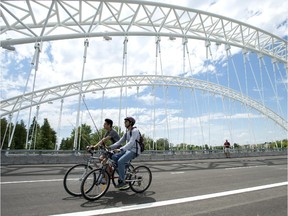 People ride bikes at the opening of the Strandherd-Armstrong Bridge in Ottawa on Saturday, July 12, 2014. The bridge connects the communities of Barrhaven and Riverside South over the Rideau River.