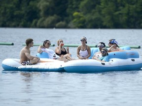 People take in the scene from a inflatable raft during the HOPE Volleyball Summerfest at Mooney's Bay Beach in Ottawa on Saturday, July 12, 2014. Justin Tang/Ottawa Citizen