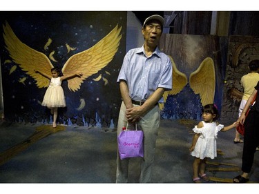 People visit an exhibit of an art work that gives the illusion of being three dimensional in Beijing, China, Saturday, July 26, 2014.