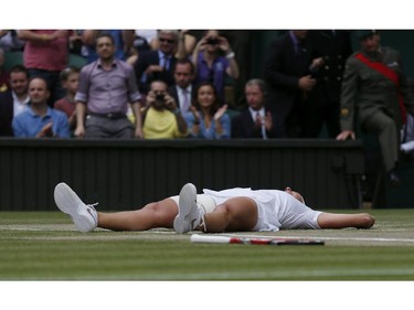 Petra Kvitova of Czech Republic lays on the court as she celebrates defeating Eugenie Bouchard of Canada in their women's singles final at the All England Lawn Tennis Championships in Wimbledon, London, Saturday July 5, 2014.