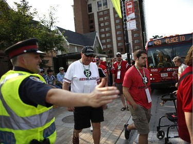 Police guided fans, many of whom took advantage of the free transit service for ticket holders, to the stadium before the Redblacks' home opener at TD Place on Friday, July 18, 2014.