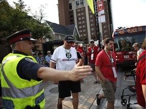 Police guided fans, many of whom took advantage of the free transit service for ticket holders, to the stadium before the Redblacks' home opener at TD Place in Ottawa on July 18, 2014.