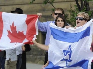 Pro-Israel counter-protesters rally from the south sidewalk of Wellington Street as pro-Palestinian supporters march along Wellington Street in Ottawa in support of Palestinians in Gaza on Tuesday, July 22, 2014.