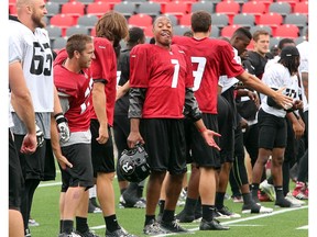 QB Henry Burris, centre, makes his teammates laugh, seemingly with some impressions during drills as the Ottawa Redblacks practice through a downpour Tuesday morning at TD Place Stadium at Lansdowne Park.