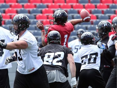 QB Henry Burris gets above the fray with the ball as the Ottawa Redblacks practice at TD Place Stadium at Lansdowne Park on Monday, July 14, 2014.