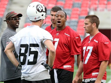 Quarterback Henry Burris, centre, has a serious discussion mid-practice as the Ottawa Redblacks have their first practice at home since losing their opening season game against Winnipeg.