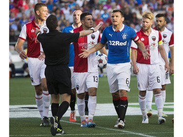 Rangers FC Lee McMulloch, right, argues with referee Mathieu Bourdeau, left, as the Ottawa Fury FC hosted the Scottish League One champion Rangers FC in the first ever international friendly game at TD Place on Wednesday, July 23, 2014.