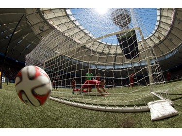 The ball bounces behind the goal off a Vancouver Whitecaps shot that went wide as FC Dallas' Walker Zimmerman, centre, dives across the goal line while goalkeeper Raul Fernandez, back, of Peru, watches during the first half of an MLS soccer game in Vancouver, B.C., on Sunday July 27, 2014.