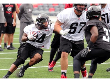 RB Michael Hayes carries the ball through heavy traffic as the Ottawa Redblacks practice at TD Place Stadium at Lansdowne Park on Monday, July 14, 2014.