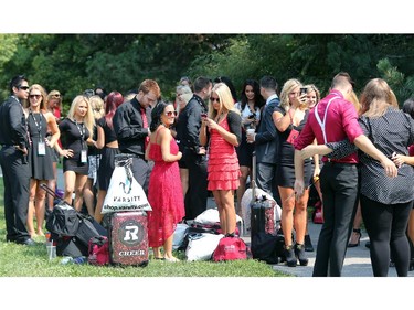 Redblacks cheerleaders take pictures and chat as they wait outside the back gate to get into stadium Friday morning. On the inaugural opening day of TD Place July 18, 2014.