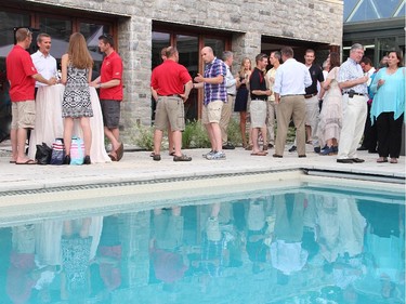 Retired astronaut Chris Hadfield, standing to the left, is seen in a poolside conversation with a couple of Snowbirds at the Hadfield Youth Summit Soirée hosted by Michael Potter on Monday, June 30, 2014, at his Rockcliffe home.