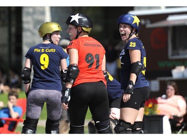 Riot Squad's BLackeyE shares a laugh with league mate AustinTatious of Slaughter Daughers during the Rideau Valley Roller Girls' Roller Derby Expo at the Rink of Dreams at Ottawa City Hall's Marion Dewar Plaza in Ottawa on Saturday, July 12, 2014.