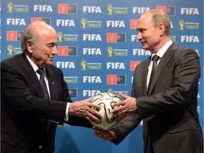 On Sunday, July 13, 2014, FIFA President Sepp Blatter, left, and Russian President Vladimir Putin hold a soccer ball during the official ceremony of handover to Russia as the 2018 World Cup hosts, after the World Cup final soccer match between Germany and Argentina at the Maracana Stadium in Rio de Janeiro, Brazil.