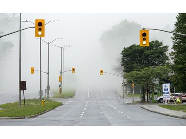 Smoke fills the air along Carling Avenue following the demolition of the Sir John Carling building in Ottawa on Sunday, July 13, 2014. The former headquarters of Agriculture and Agri-Food Canada at 930 Carling, completed in 1967, is being demolished at a cost of $4.8 million.