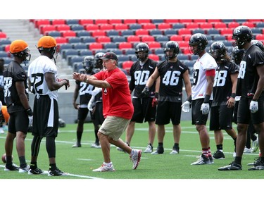 Special Teams/Running Backs coach Don Yanowsky shows a player what he wants on the field as the Ottawa Redblacks practice at TD Place Stadium at Lansdowne Park on Monday, July 14, 2014.
