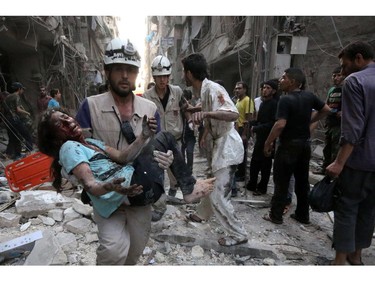 A rescue worker carries a wounded girl following a reported air strike by Syrian government forces on July 27, 2014 in the northern city of Aleppo. Elsewhere, Islamic State (IS) militants killed 15 Syrian rebels in an ambush as the jihadists tried to advance on Aleppo province, the Syrian Observatory for Human Rights said.